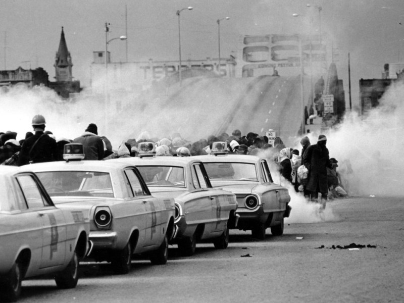 In this March 7, 1965 file photo, clouds of tear gas fill the air as state troopers, ordered by Gov. George Wallace, break up a demonstration march in Selma, Ala., on what became known as "Bloody Sunday." The incident is widely credited for galvanizing the nation's leaders and ultimately yielded passage of the Voting Rights Act of 1965. (AP Photo/File