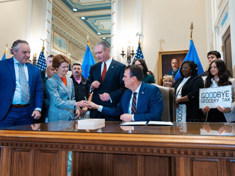 Governor Kevin Stitt takes a pen from Senator Kay Floyd to sign the bill that ends the Oklahoma grocery tax. Feb. 27, 2024.