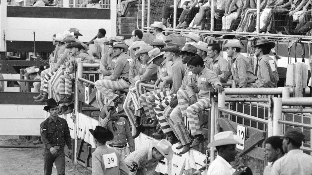 To separate the inmates from the professional cowboys participating in the rodeo at the Oklahoma State Penitentiary, trousers with prison stripes are worn by the inmates, seen Sept. 29, 1971, in McAlester, Oklahoma. (AP Photo/Eddie Adams)