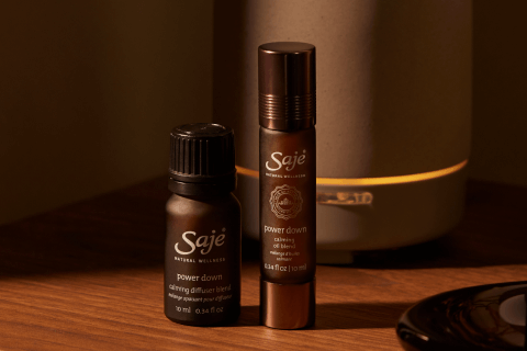 Power Down Diffuser Blend and Power Down Roll-On placed on a wooden nightstand